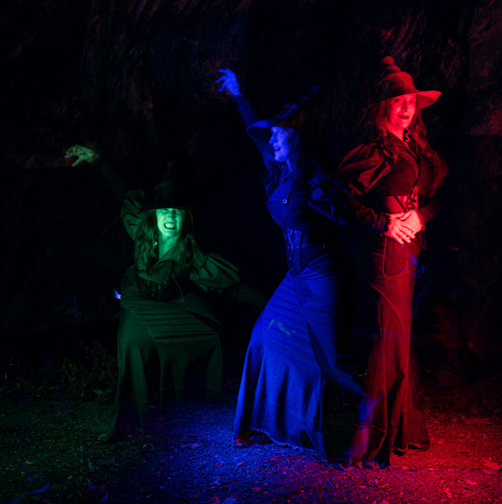 Multiple exposure of model in witch outfit, lit in green, blue and red. 
